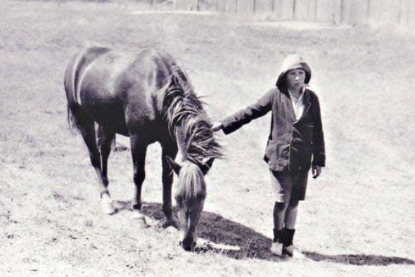 A nine year old boy riding a pony